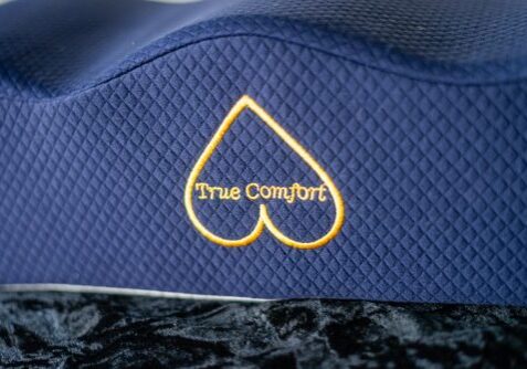 A blue hat with the words " true comfort " embroidered on it.